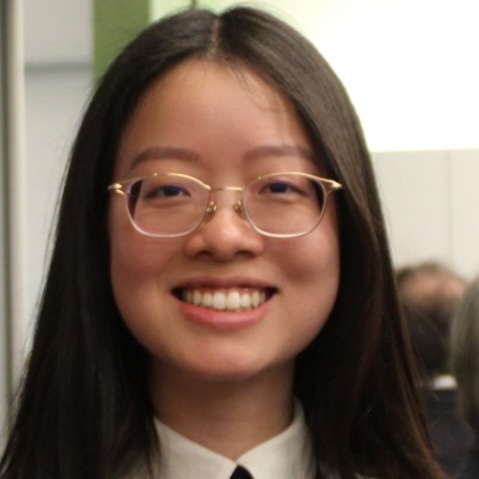 A headshot of a woman with long straight hair and glasses.